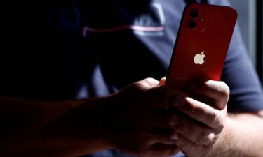 A man poses with an Apple iPhone 12 in a mobile phone store in Nantes