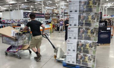 A worker guides a pallet of goods to a display spot in a Costco warehouse on July 8