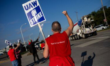 United Auto Workers (UAW) members cheer as cars honk on a picket line outside the Ford Motor Co. Michigan Assembly plant in Wayne