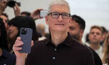 Apple CEO Tim Cook holds the new iPhone 14 at an Apple event at their headquarters in Cupertino