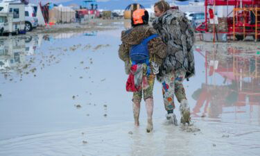 Burning Man attendees walk through the mud on September 2.