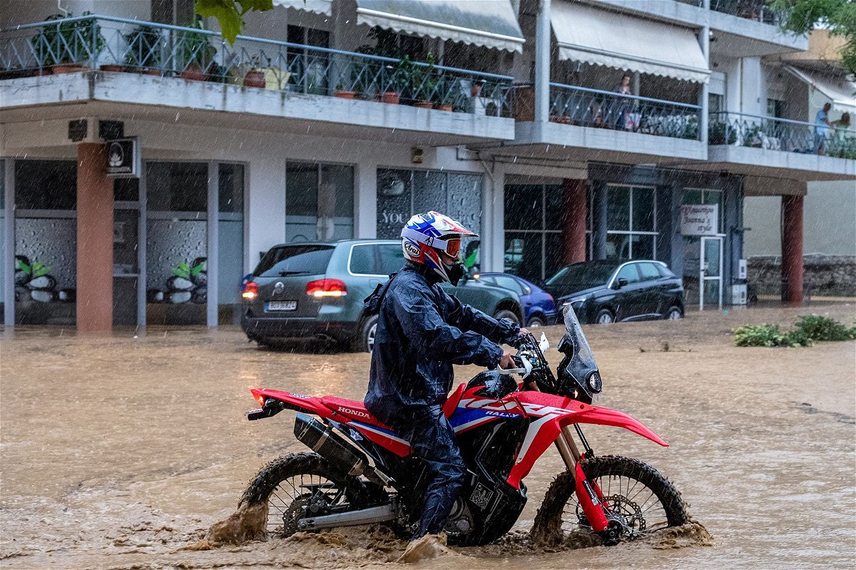 <i>Anastasia Karekla/Eurokinissi/Reuters</i><br/>A man drives his bike in rising waters