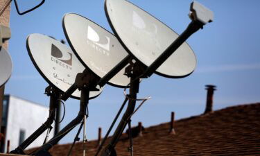DirecTV satellite dishes are seen on an apartment roof in Los Angeles