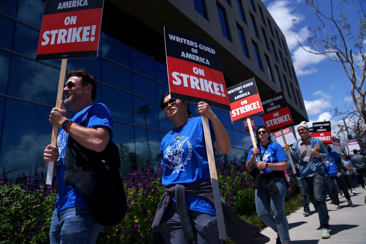 <i>Eric Thayer/Getty Images</i><br/>Striking Writers Guild of America workers picket outside the Sunset Bronson Studios building on May 2