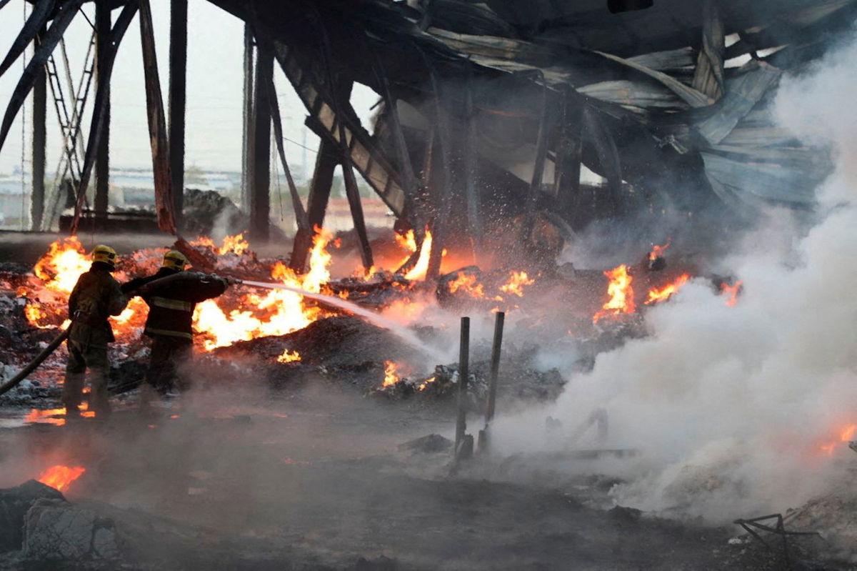 <i>Uzbek Government/Reuters</i><br/>Firefighters work to extinguish a blaze following an explosion at a warehouse near an airport in Tashkent