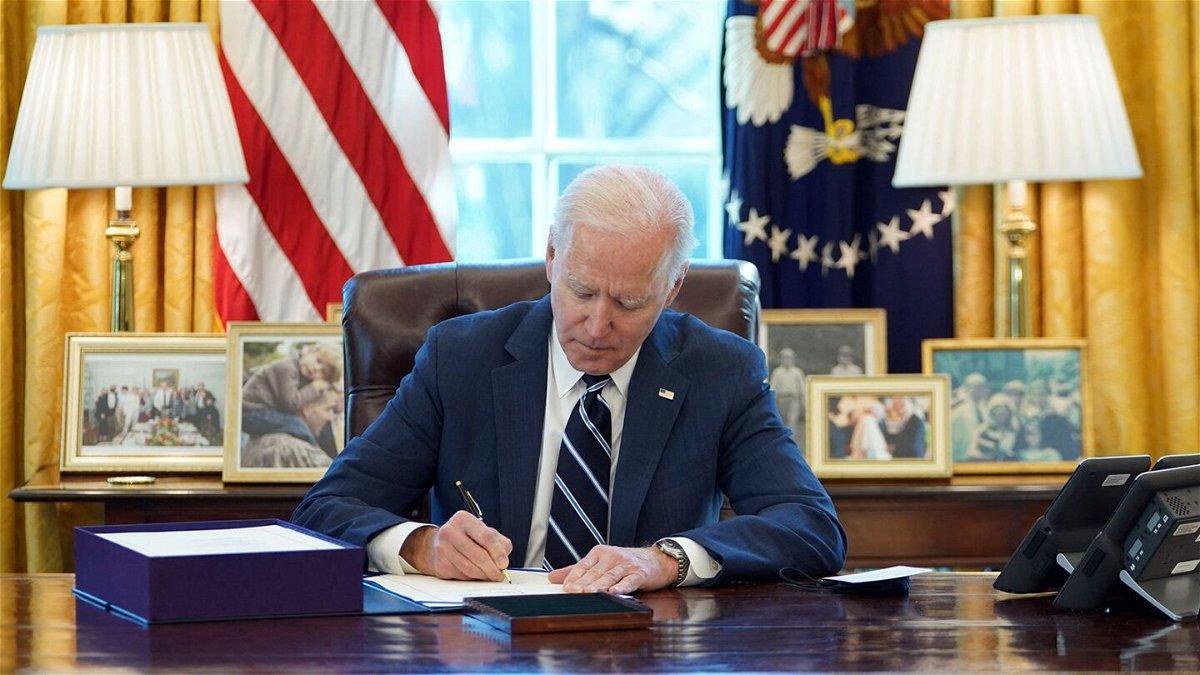 <i>Mandel Ngan/AFP/Getty Images</i><br/>US President Joe Biden signs the American Rescue Plan in March 2021
