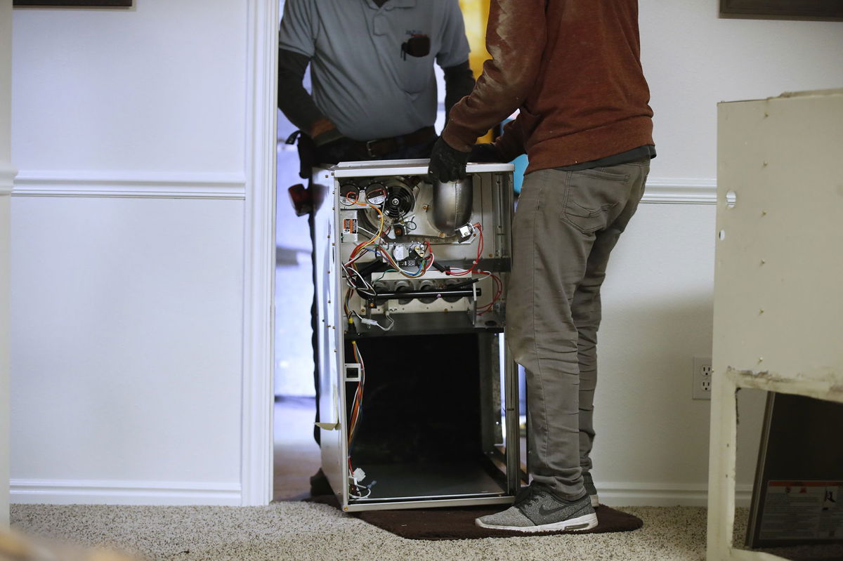 <i>George Frey/Bloomberg/Getty Images</i><br/>Workers carry a new Carrier natural gas furnace to install at a residential home in Spanish Fork