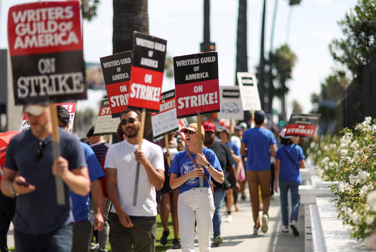 <i>Mario Anzuoni/Reuters</i><br/>SAG-AFTRA actors and Writers Guild of America writers walk the picket line during their strike outside Netflix offices in Los Angeles earlier this month.