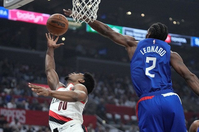 Portland Trail Blazers guard Scoot Henderson, left, shoots as Los Angeles Clippers forward Kawhi Leonard defends during the first half of Wednesday night's season opener in Los Angeles
