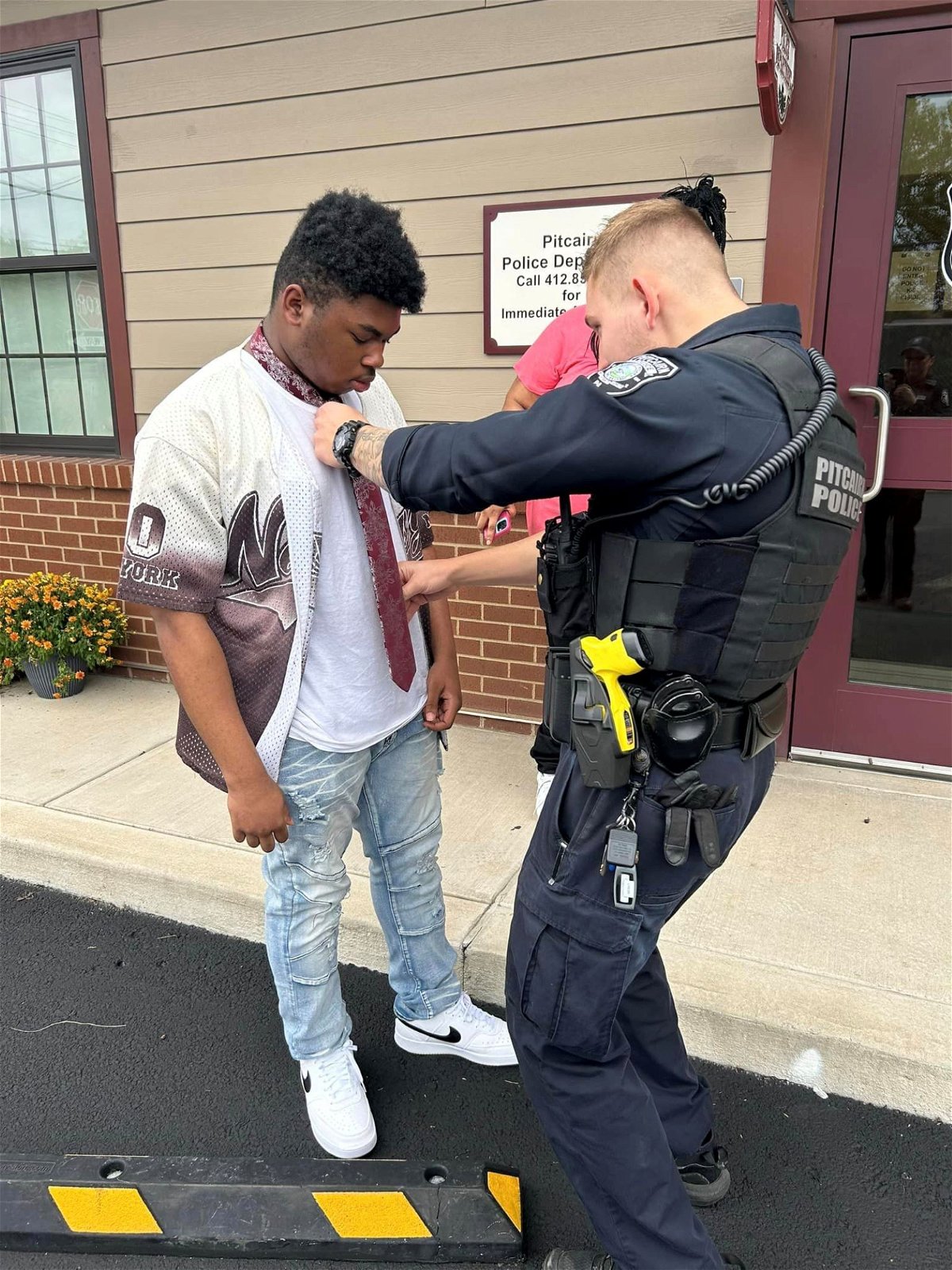 <i>Pitcairn Police Department/KDKA</i><br/>An officer with the Pitcairn Police Department stepped in to help a teen with his tie for his first school dance.