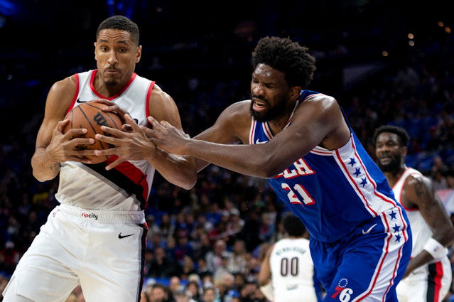 Portland Trail Blazers' Malcolm Brogdon, left, steals the ball from Philadelphia 76ers' Joel Embiid, right, during the first half of Sunday night's game in Philadelphia