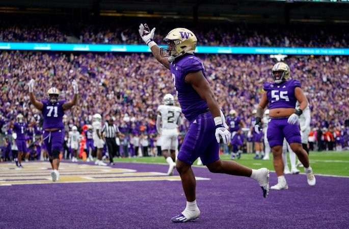 Washington running back Dillon Johnson reacts after scoring a touchdown against Oregon during the first half of Saturday's game in Seattle