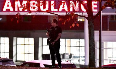 An armed police officer guards the ambulance entrance to the Central Maine Medical Center in Lewiston