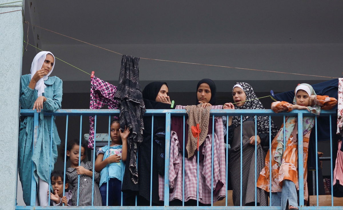 <i>Mahmud Hams/AFP/Getty Images</i><br/>Palestinians carrying their belongings flee to safer areas in Gaza City after Israeli airstrikes on October 13