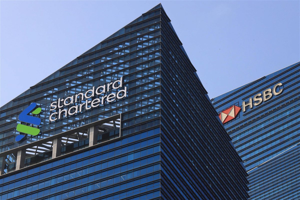 <i>Suhaimi Abdullah/NurPhoto/Getty Images</i><br/>Signage of Standard Chartered Plc and HSBC Holding Plc sit atop of buildings at the Marina Bay financial district on October 12