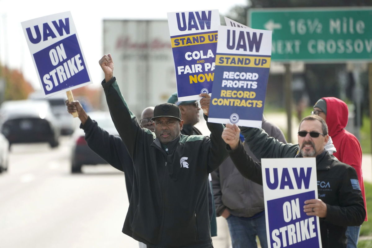 <i>Paul Sancya/AP/File</i><br/>Members of the United Auto Workers union strike at a Stellantis plant in Michigan on October 23. The company has taken a $3.2 billion hit as a result of the walkouts.