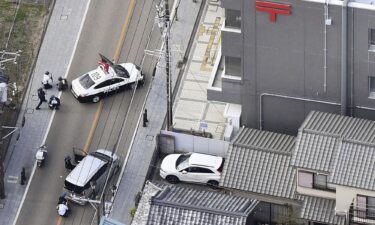 First responders take position outside the post office where a man is believed to holed up in Warabi