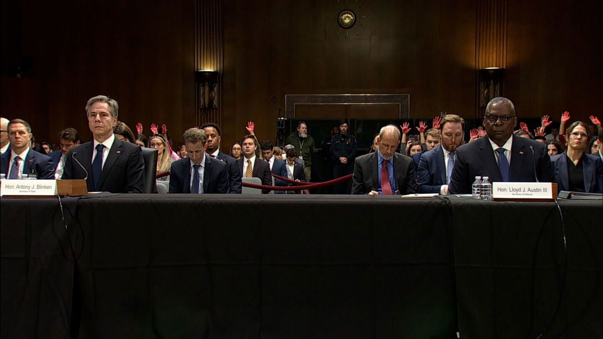 <i>Pool</i><br/>United States Secretary of State Antony Blinken and Secretary of Defense Lloyd Austin testify on Capitol Hill as people protest behind them on October 31.