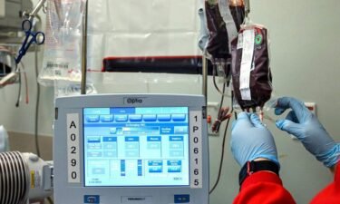 A worker from the Community Blood Center hangs a bag of blood during a transfusion for Kevin Wake at the Sickle Cell Center at University Health on March 7.