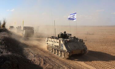 Israeli armored personnel carriers (APCs) maneuver at an area along the border with Gaza