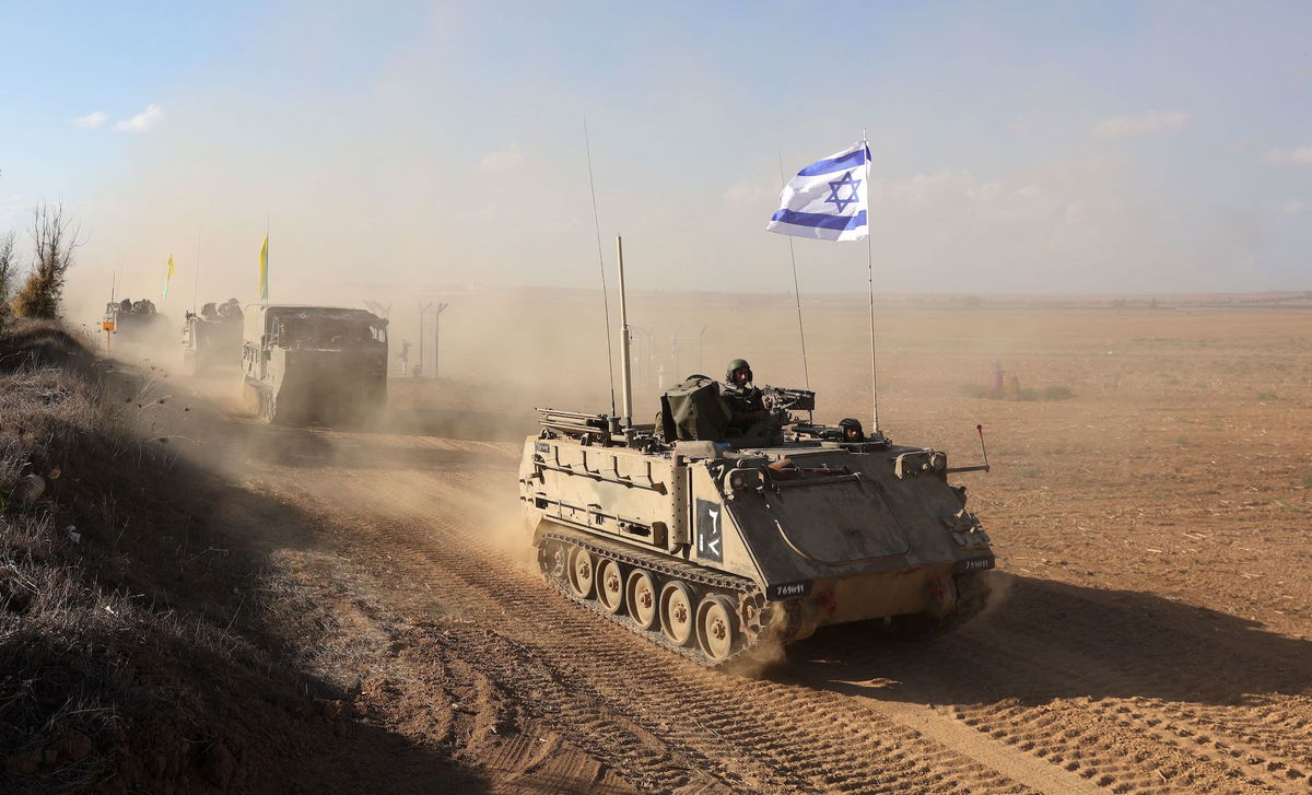 <i>Abir Sultan/EPA-EFE/Shutterstock</i><br/>Israeli armored personnel carriers (APCs) maneuver at an area along the border with Gaza