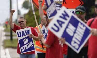 United Auto Workers member Mariusz Mirek holds a picket sign near a General Motors Assembly Plant in Delta Township