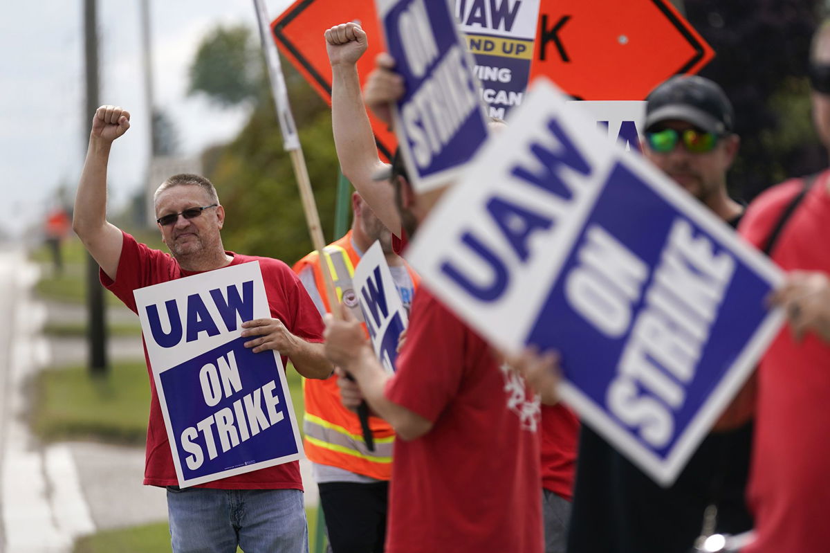 <i>Paul Sancya/AP</i><br/>United Auto Workers member Mariusz Mirek holds a picket sign near a General Motors Assembly Plant in Delta Township