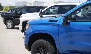 Unsold 2023 Silverado pickup trucks sit in a long row at a Chevrolet dealership Sunday