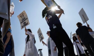 Striking Kaiser Permanente workers hold signs as they march in front of the Kaiser Permanente San Francisco Medical Center on October 04