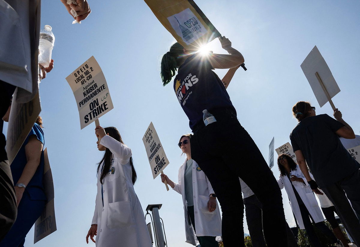 <i>Justin Sullivan/Getty Images</i><br/>Striking Kaiser Permanente workers hold signs as they march in front of the Kaiser Permanente San Francisco Medical Center on October 04