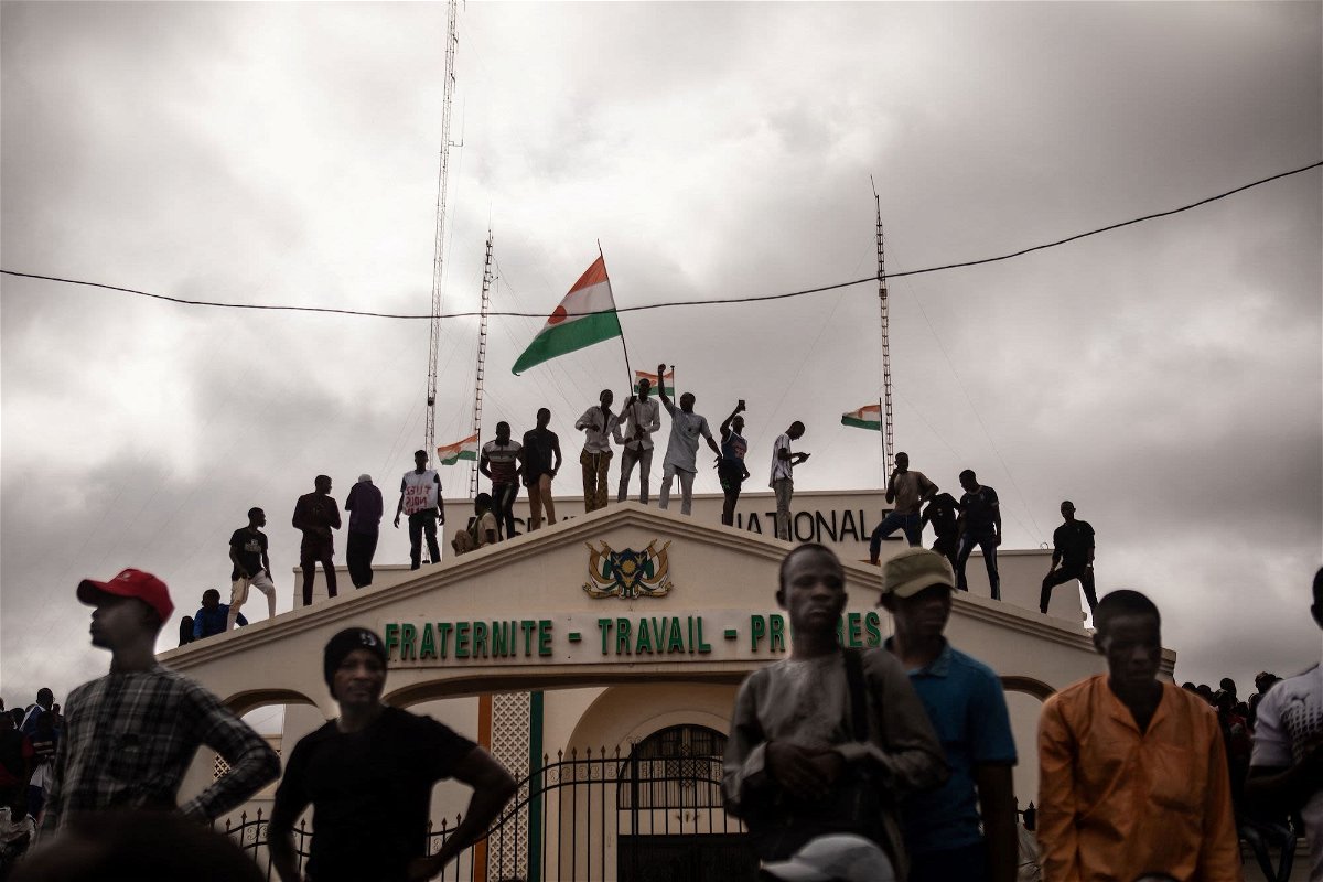 <i>Stringer/AFP/Getty Images</i><br/>Protesters hold a Niger flag during a demonstration on independence day in Niamey on August 3.