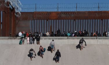 Migrants approach the border wall in Ciudad Juarez