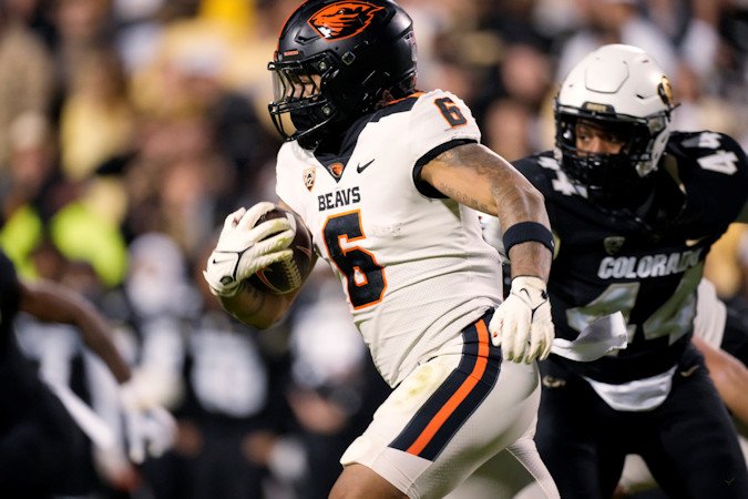 Oregon State running back Damien Martinez runs for a short gain as Colorado linebacker Jordan Domineck pursues during the first half of Nov. 4 contest in Boulder
