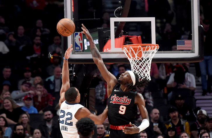 Portland Trail Blazers forward Jerami Grant, right, blocks a shot by Memphis Grizzlies guard Desmond Bane, left, during the first half of Friday night's NBA game in Portland