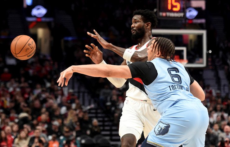 Memphis Grizzlies forward Kenneth Lofton Jr., right, knocks the ball away from Portland Trail Blazers center Deandre Ayton, left, during the first half of  Sunday night's game in Portland