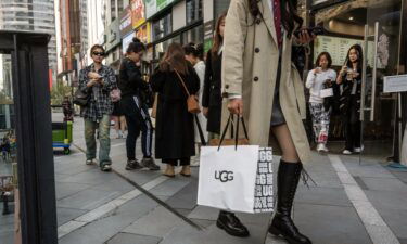A shopper carries an Ugg Holdings Inc. bag in the Sanlituan area of Beijing