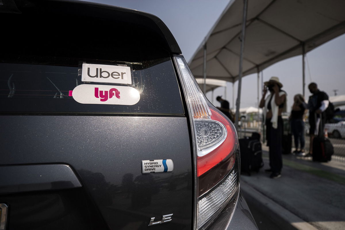 <i>Etienne Laurent/EPA-EFE/Shutterstock</i><br/>The Uber and Lyft stickers are displayed on a car at LAX Rideshare Lot 1 in Los Angeles