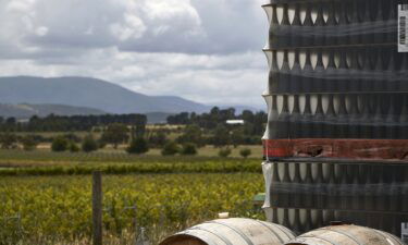 Wine barrels and pallets of bottles are stacked at a winery in the Yarra Valley