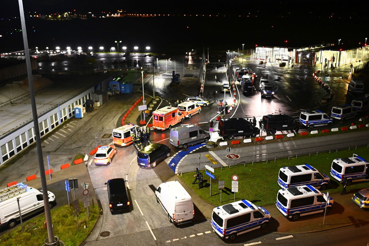 <i>Jonas Walzberg/picture-alliance/dpa/AP</i><br/>Police vehicles and ambulances arrive at the scene of a security breach at Hamburg Airport