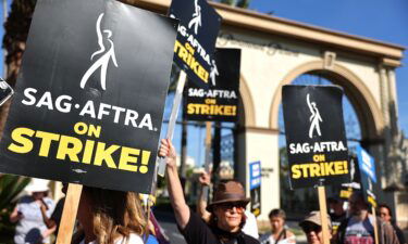SAG-AFTRA member Caryn West (C) and other members and supporters picket outside Paramount Studios on day 113 of their strike against the Hollywood studios on November 3 in Los Angeles