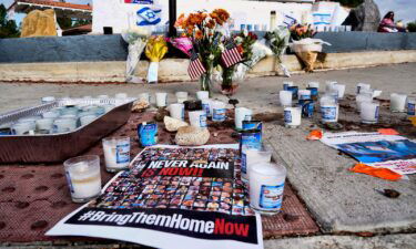 Flowers and candles are left at a makeshift shrine placed at the scene in Thousand Oaks