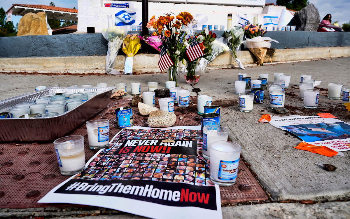<i>Richard Vogel/AP</i><br/>Flowers and candles are left at a makeshift shrine placed at the scene in Thousand Oaks