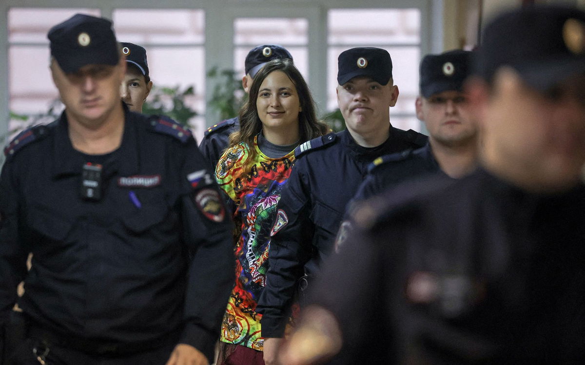 <i>Anton Vaganov/Reuters</i><br/>Artist Alexandra Skochilenko is escorted by police officers before a court hearing in Saint Petersburg