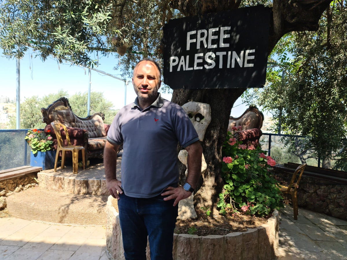 <i>Tara John/CNN</i><br/>An Israeli settlement in Hebron is covered in flags and signs on November 17.