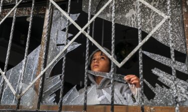 A relative tries to salvage some personal items from the home of a Palestinian family a day after it was hit by Israeli bombardment