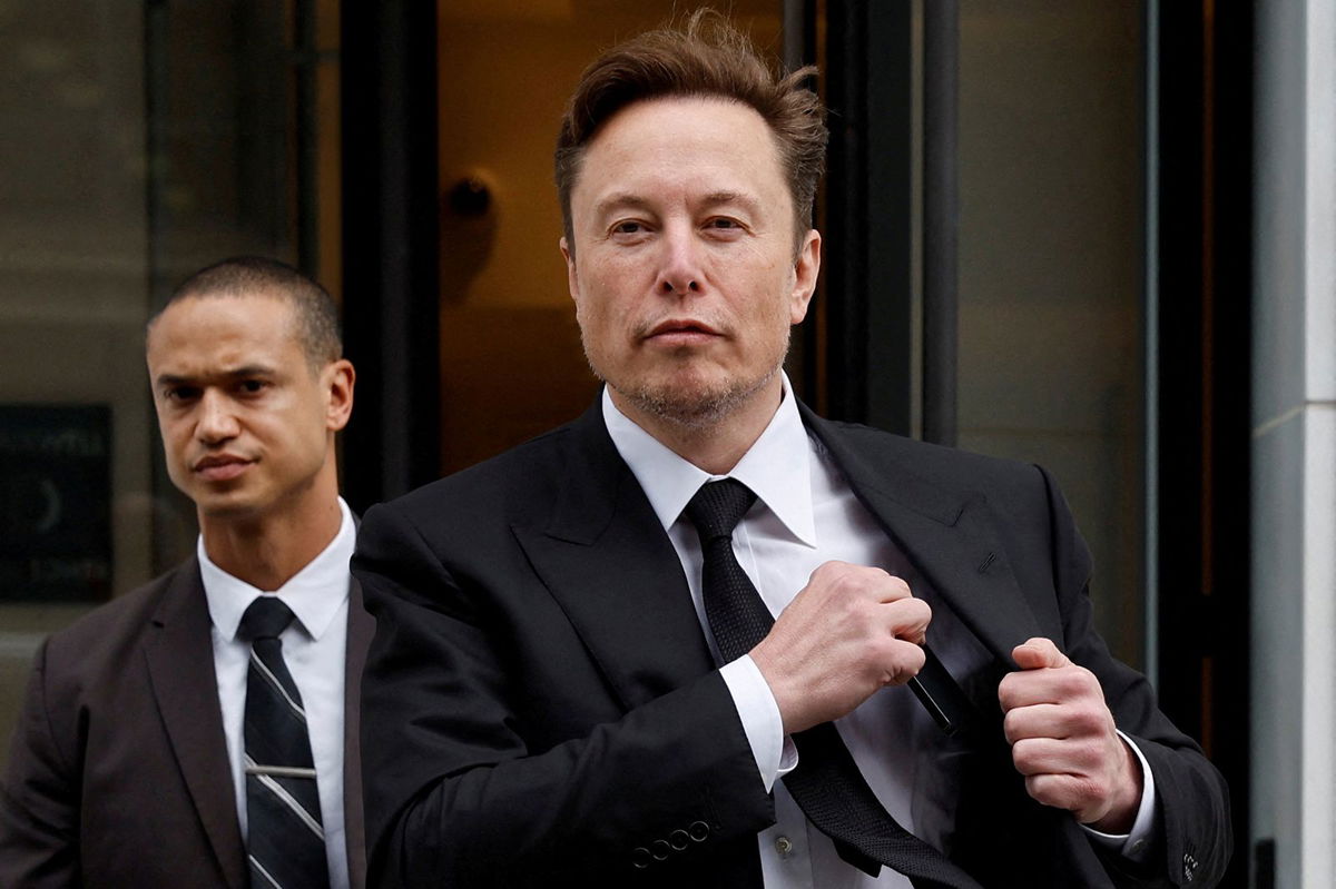 <i>Jonathan Ernst/Reuters</i><br/>Tesla CEO Elon Musk and his security detail depart the company's local office in Washington