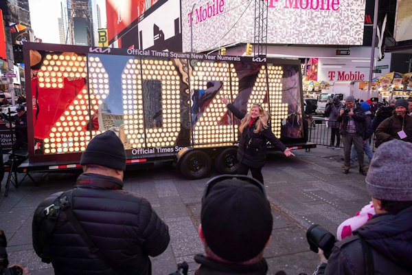 People pose in front of the 2024 New Year's Eve numerals displayed in Times Square on December 20, 2023, in New York.
