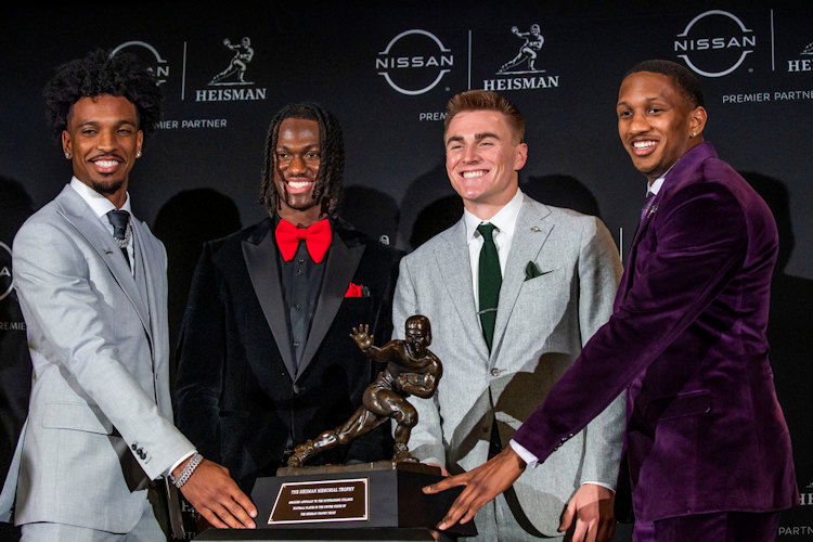 Heisman Trophy finalists, from left, LSU quarterback Jayden Daniels, Ohio State wide receiver Marvin Harrison Jr., Oregon quarterback Bo Nix and Washington quarterback Michael Penix Jr. pose with the trophy after attending a news conference before the award ceremony on Saturday in New York.