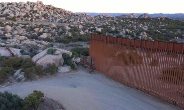 US Border Patrol agent talk to migrants as they await processing at the US-Mexico border in San Diego County.