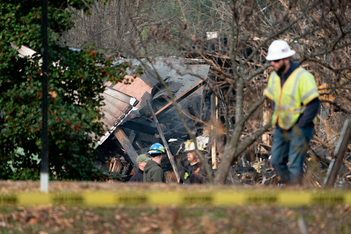 <i>Stefani Reynolds/AFP/Getty Images</i><br/>Authorities gather Tuesday at the scene of a home that exploded a day earlier in Arlington